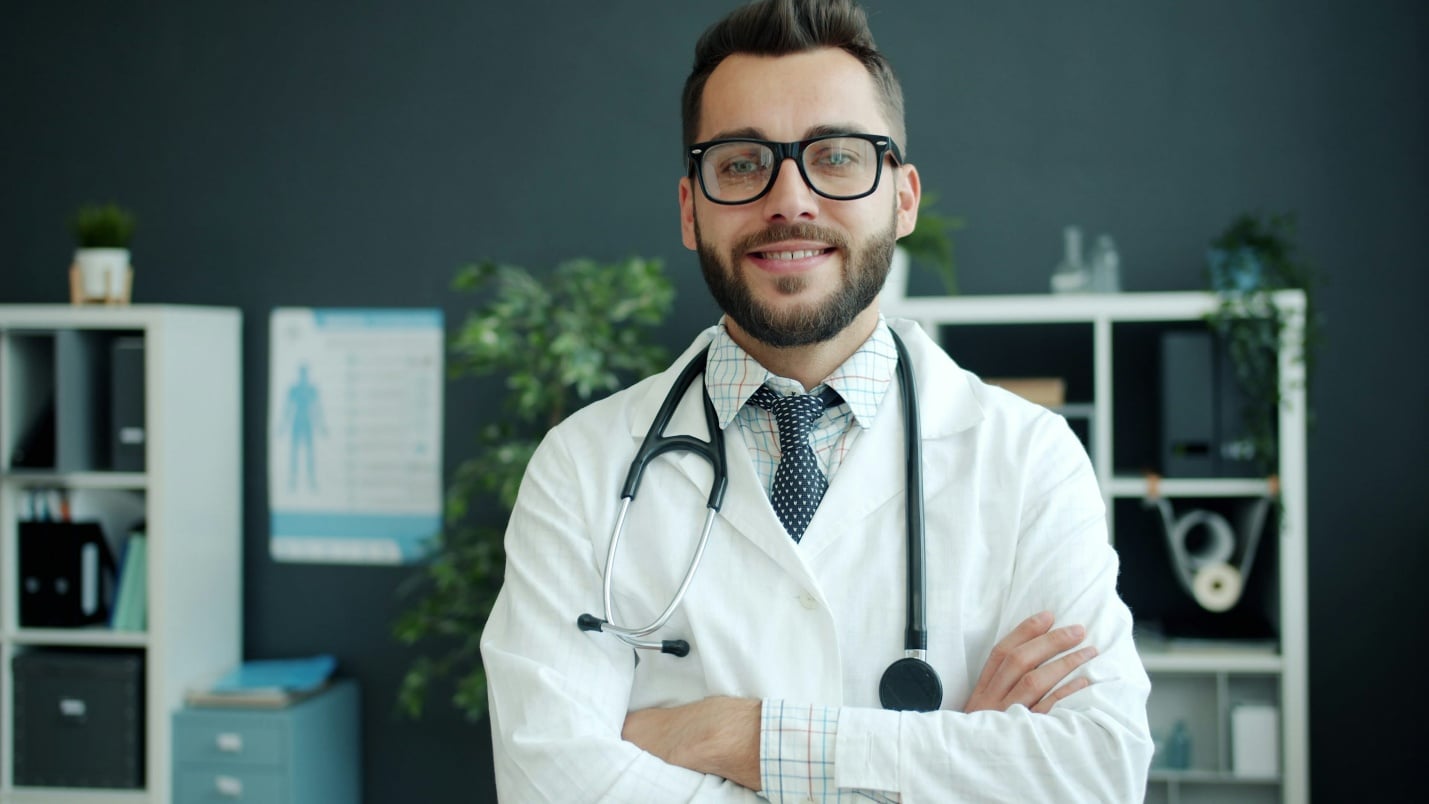 Doctor standing confidently in a clinic setting representing trusted online documentation services