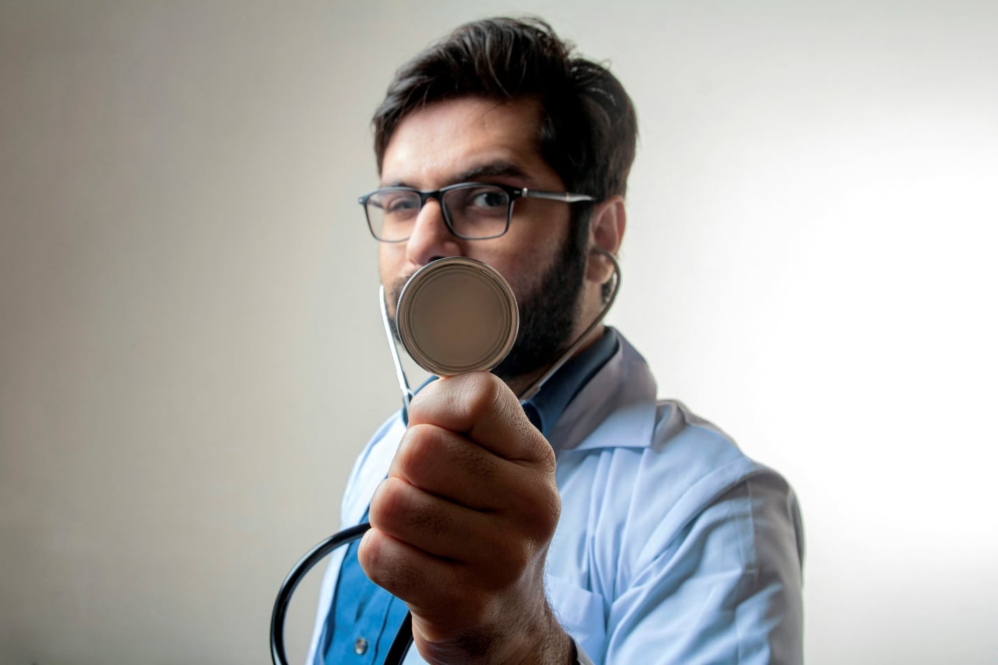 Doctor holding a stethoscope forward symbolizing medical verification during consultation