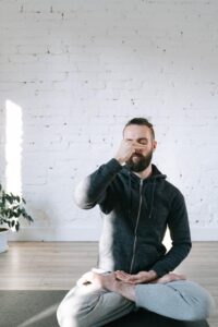 A man practicing alternate nostril breathing.