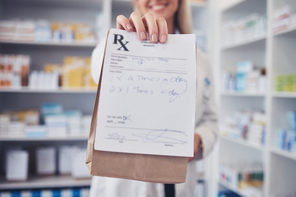 Healthcare professional holding a prescription and medical documentation issued through telehealth urgent care