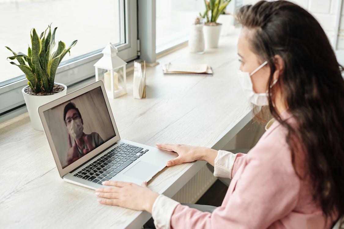 Patient attending a telehealth consultation from home using a laptop with a doctor on video