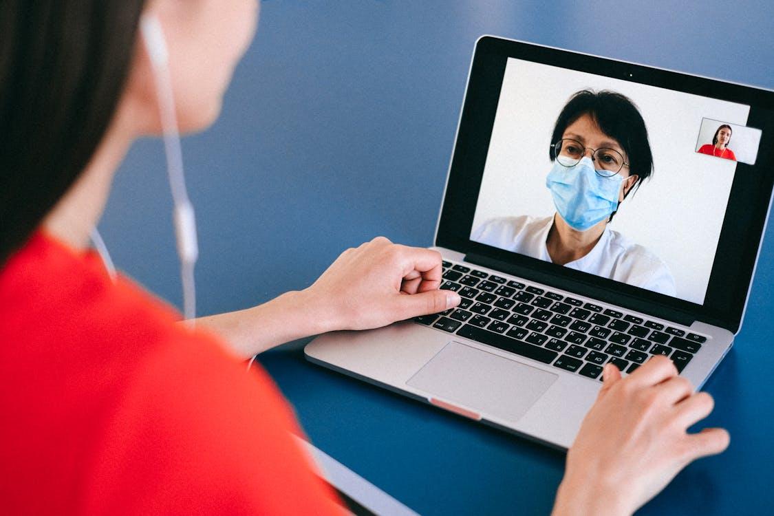 Patient participating in a telemedicine video consultation with a doctor on a laptop