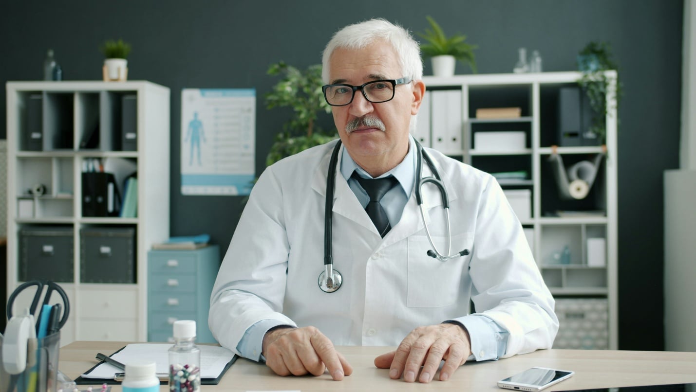 Doctor sitting in a clinic office ready to conduct a virtual healthcare consultation