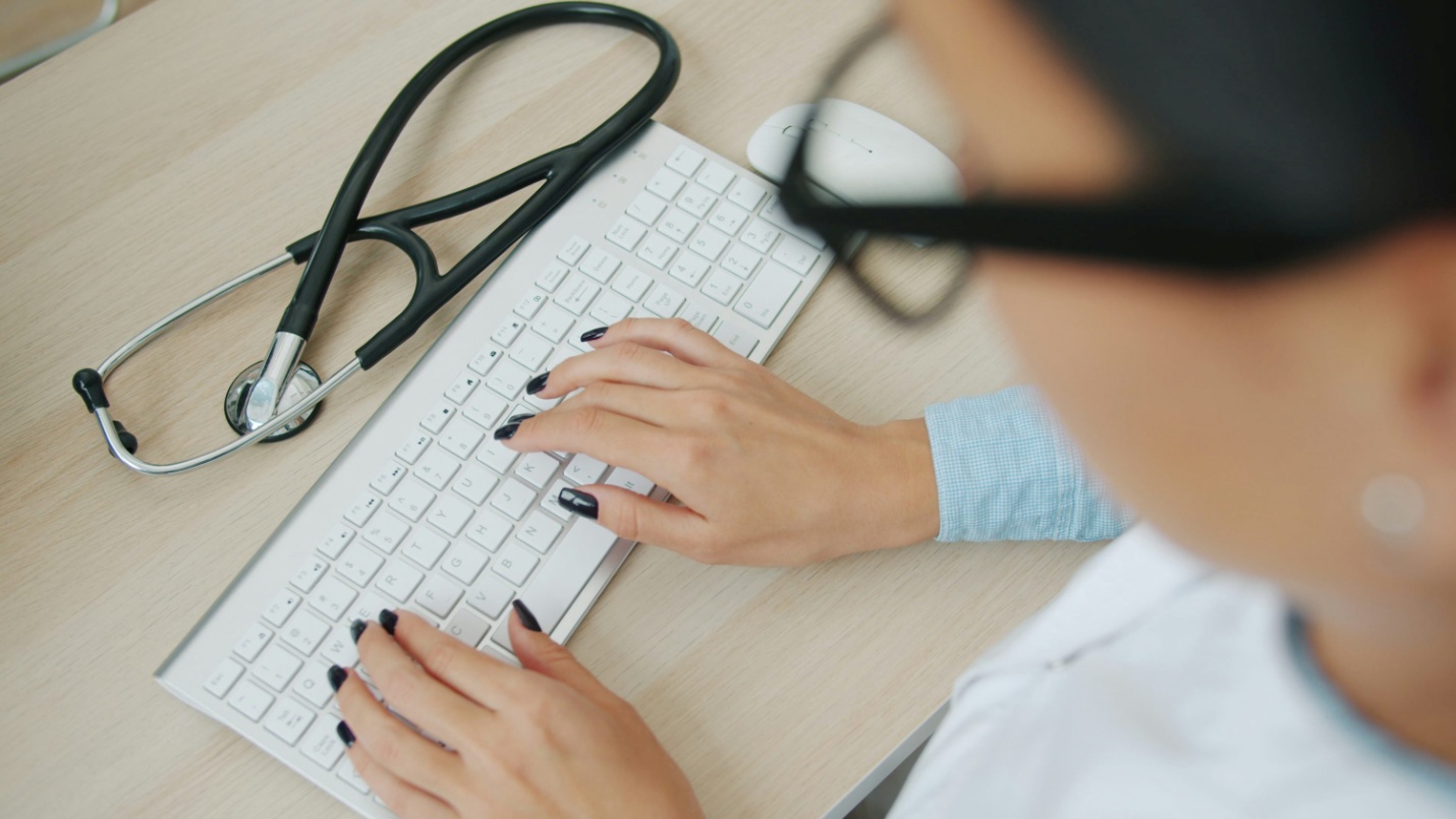 A doctor typing on a keyboard