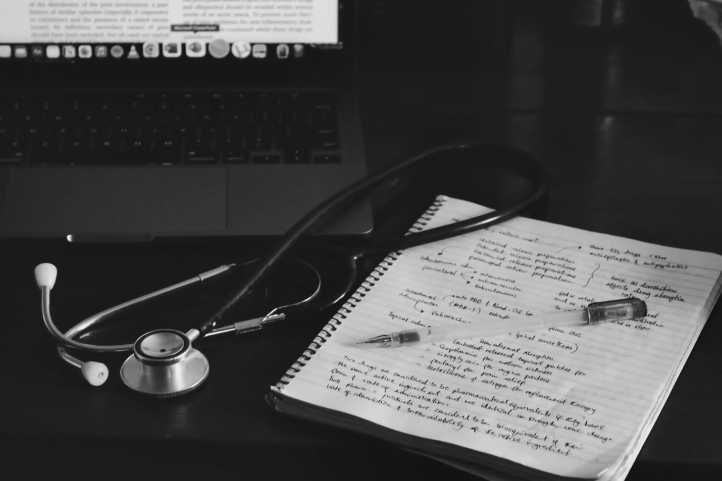 A notebook next to a stethoscope