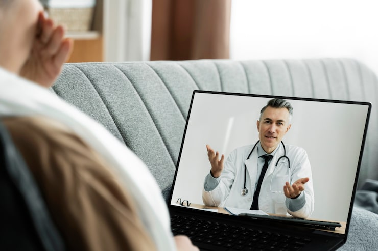 Patient participating in a telehealth consultation with a doctor through a laptop video call.
