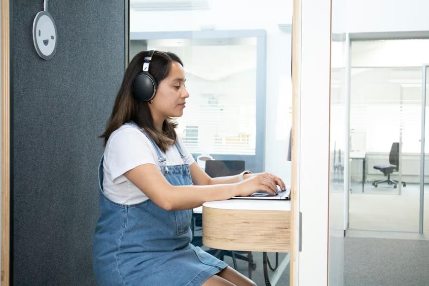 A person wearing headphones and working on a laptop