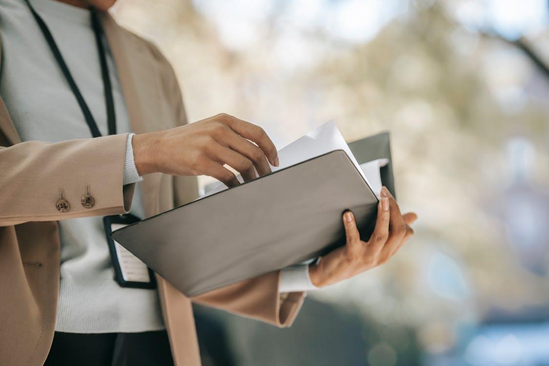 A person holding a folder with documents