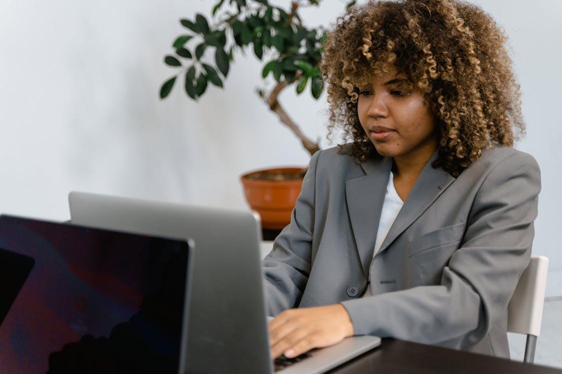 A person in a gray suit using a laptop