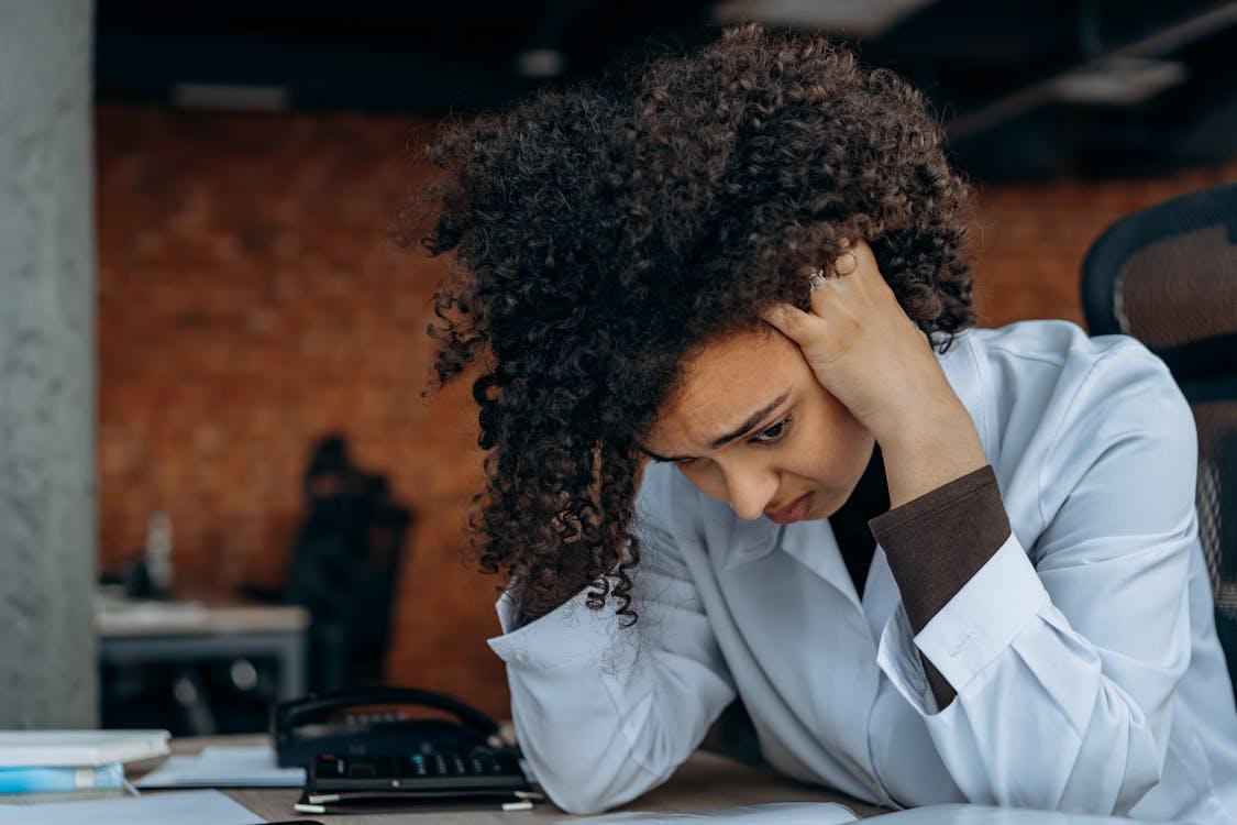 A person holding their head after getting overwhelmed in the office