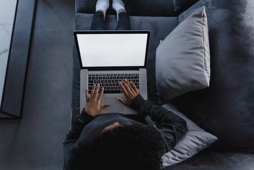 Top shot of a person using a laptop on a couch