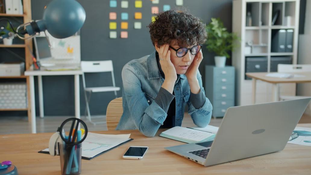 A person experiencing sensory overload while working in an office