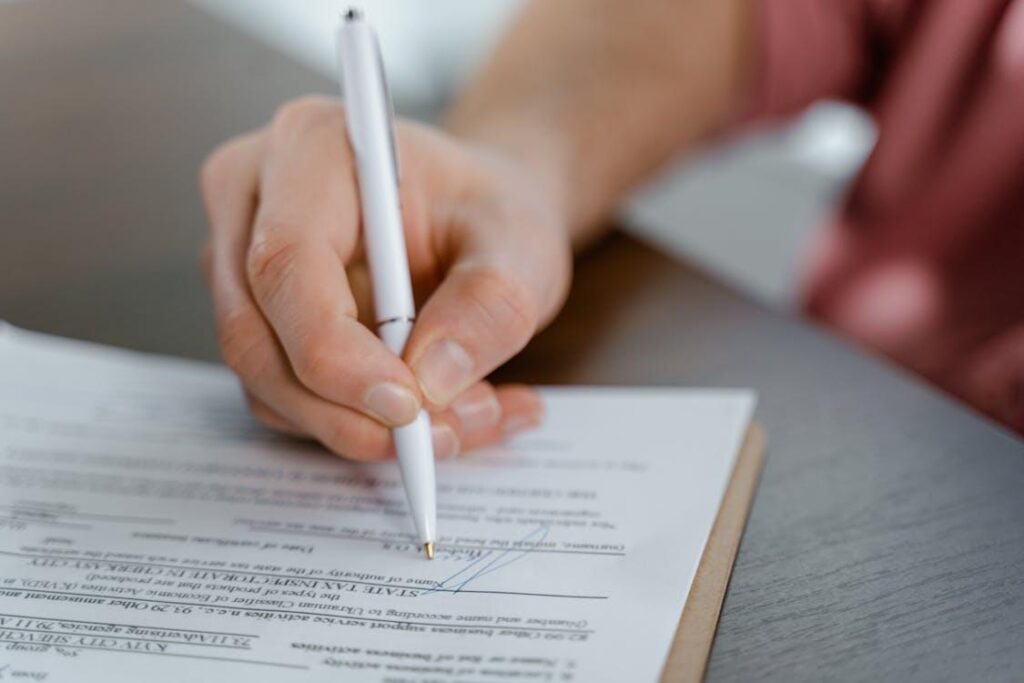 A person signing on a paper