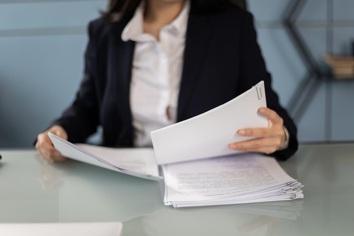 A person in a blazer reviewing papers