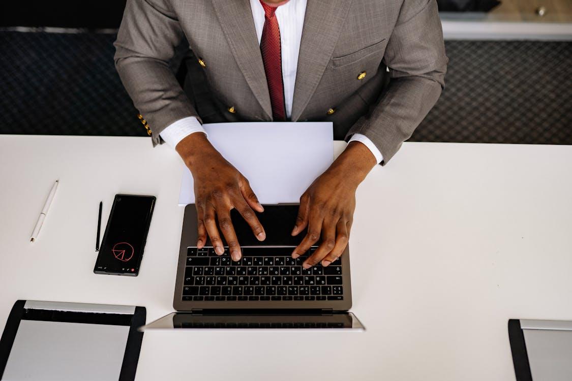 Top shot of a person in a suit using a laptop