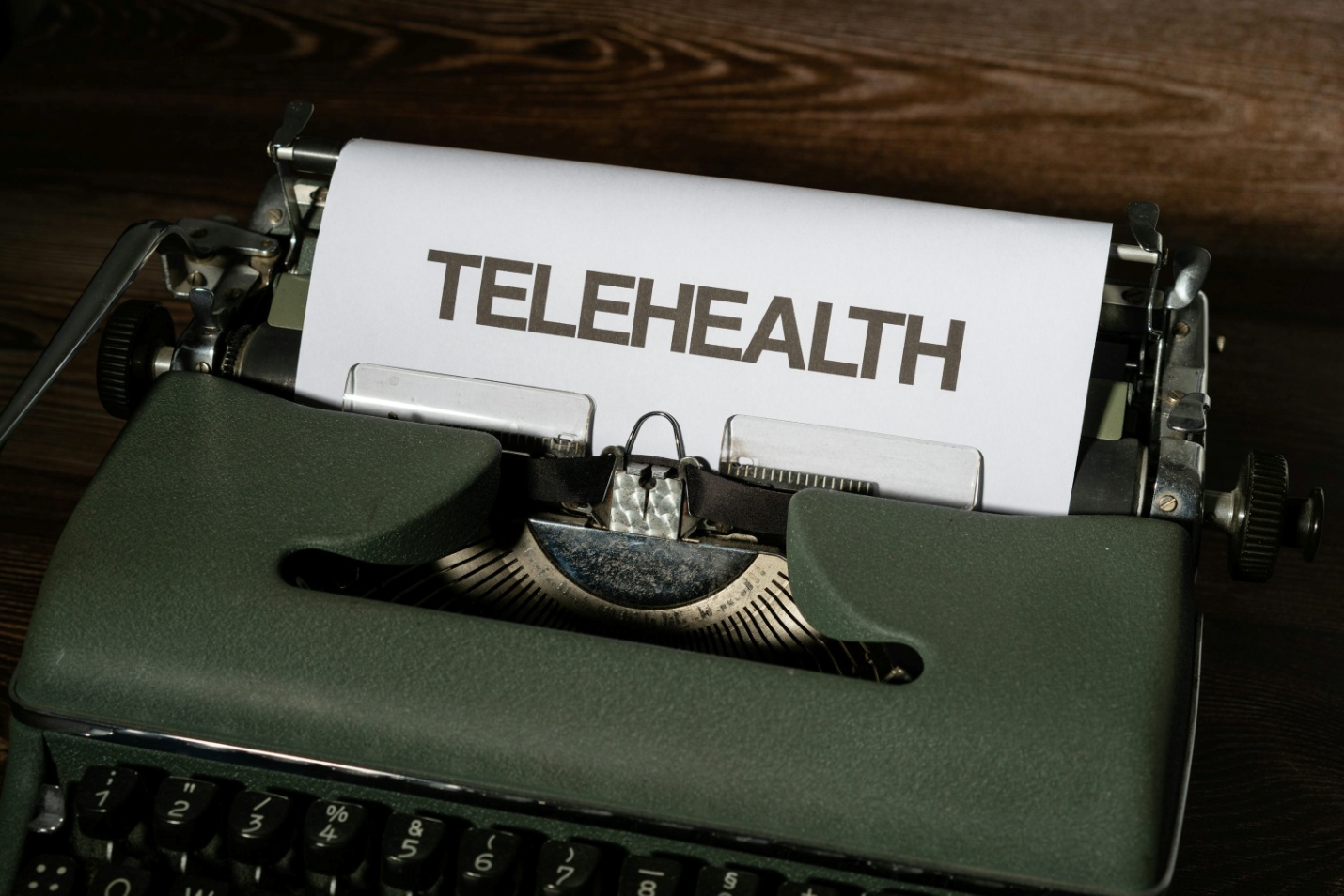A typewriter with a piece of paper with ‘telehealth’ written on it
