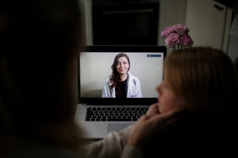 Patient having an online urgent care check-up with a doctor on a laptop at home